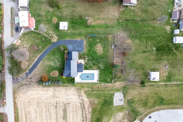 an aerial view of a house with a garden and lake view