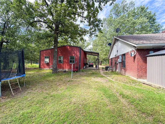 a view of backyard of house with wooden deck and seating space