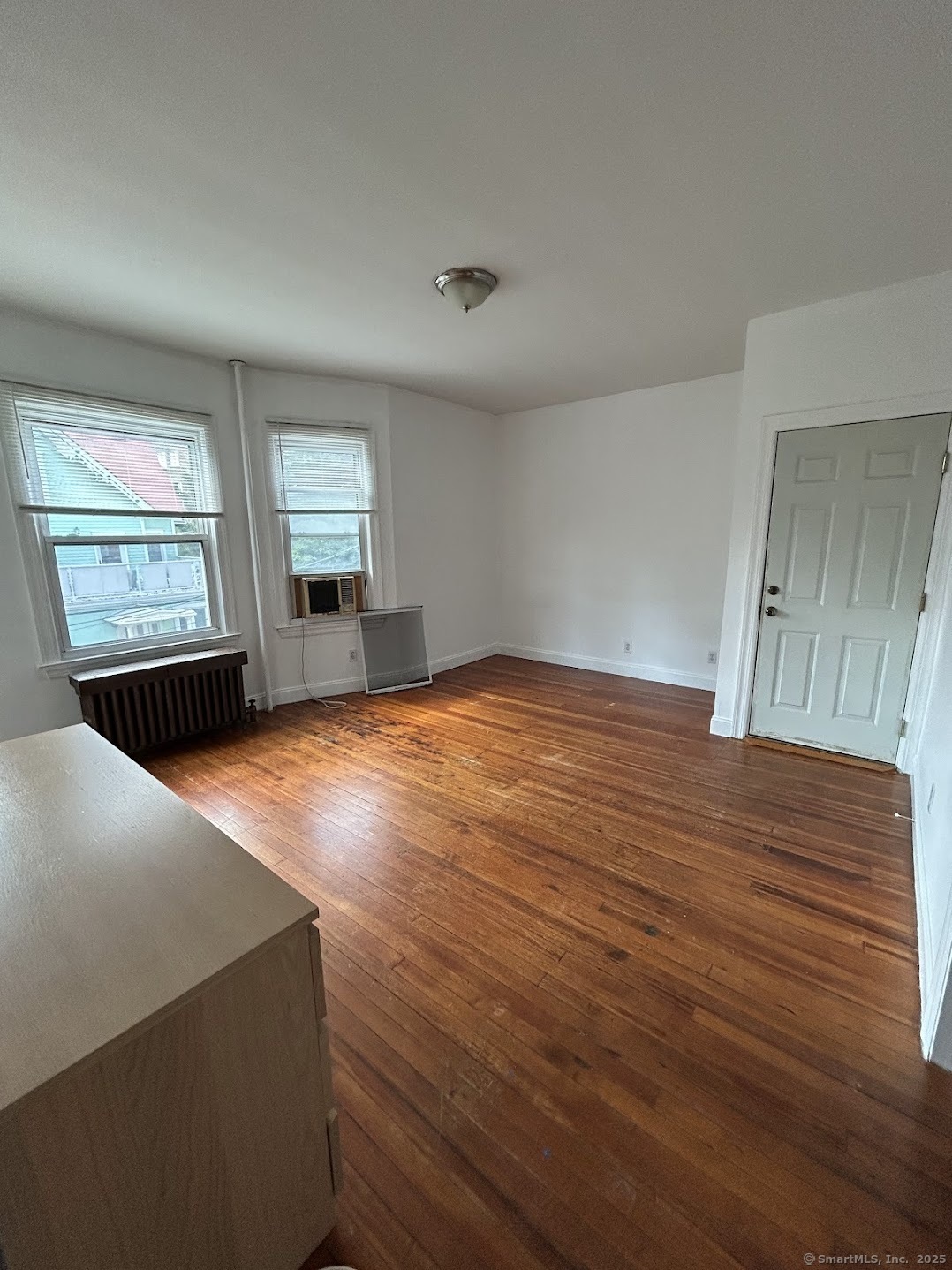 14 Relay Place, Unit L2 Stamford, CT 06901 - Photo 1 of 15 a view of an empty room with wooden floor and a window