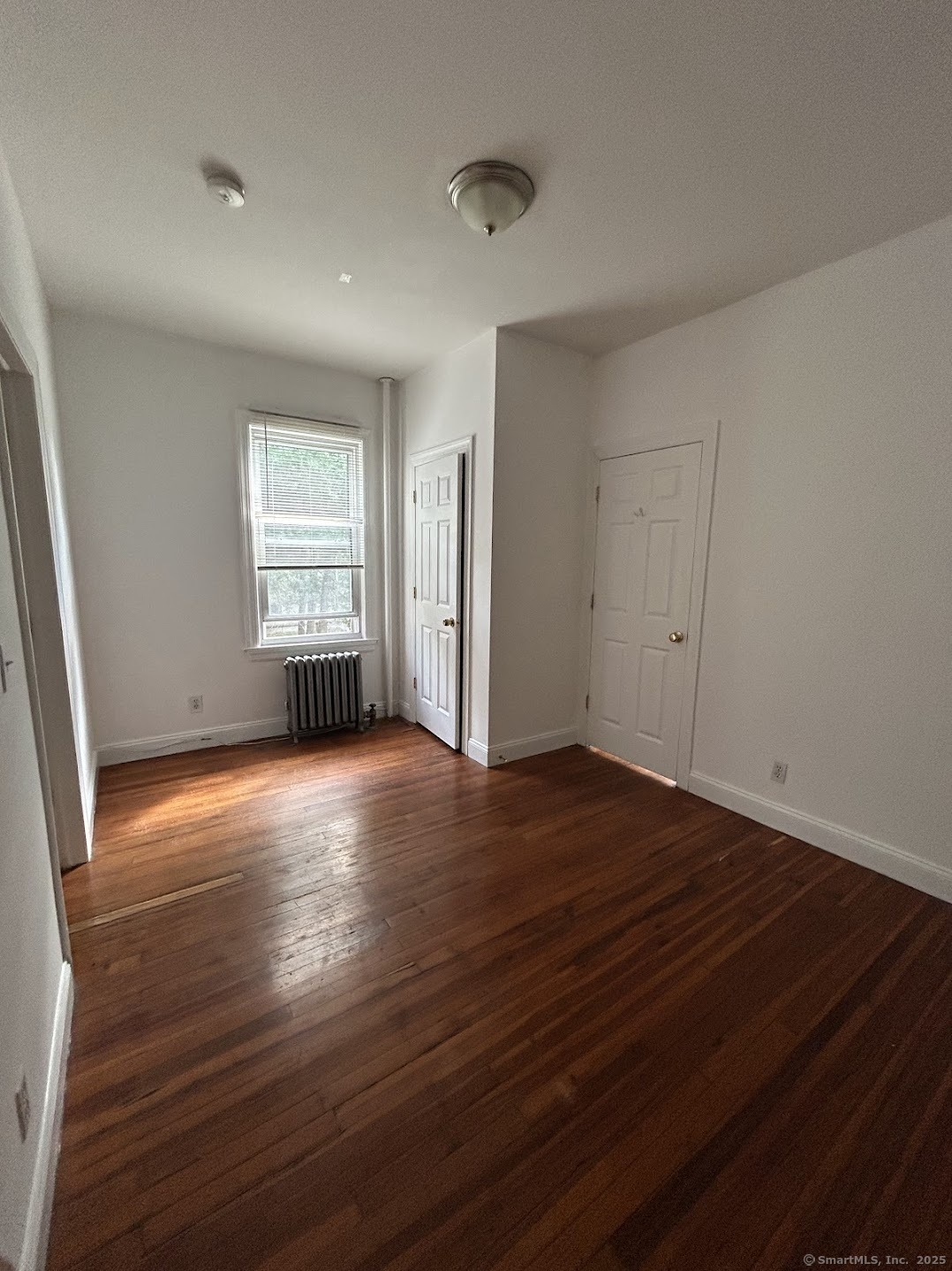 14 Relay Place, Unit L2 Stamford, CT 06901 - Photo 2 of 15 an empty room with wooden floor and windows