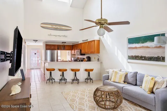 a living room with furniture kitchen view and a chandelier