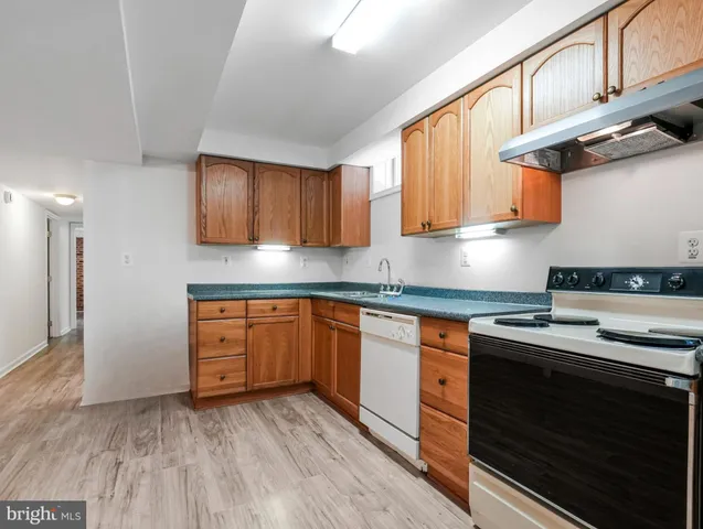 a kitchen with stainless steel appliances granite countertop wooden cabinets a stove a sink and a microwave