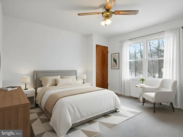 a spacious bedroom with a bed a couch and a chandelier