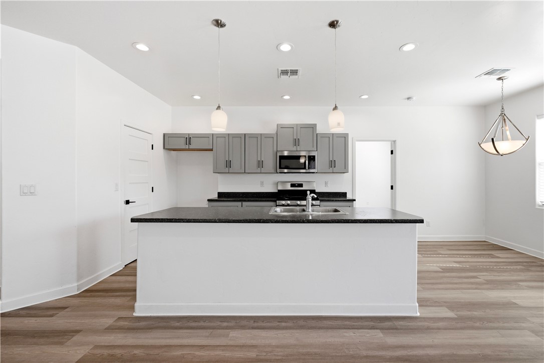 3546 North Skylark Road Kingman, AZ 86409 - Photo 3 of 30 a large kitchen with stainless steel appliances granite countertop a stove a sink a refrigerator and white cabinets with wooden floor