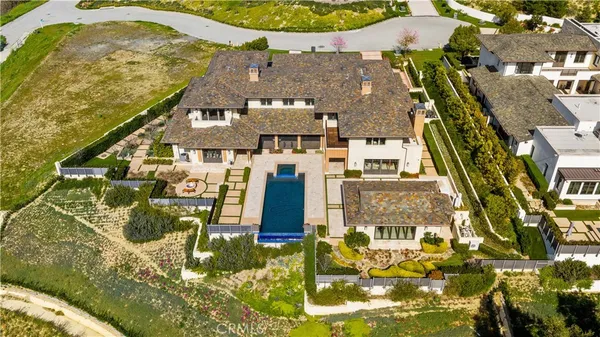 an aerial view of residential houses with outdoor space and trees