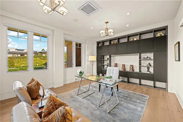 a living room with furniture a chandelier and a dining table