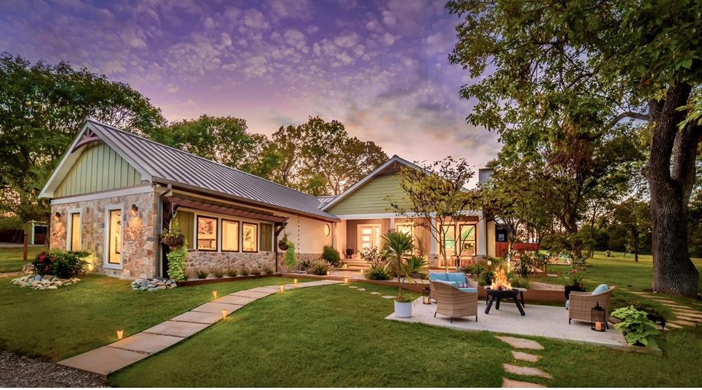 a front view of a house with a garden and trees