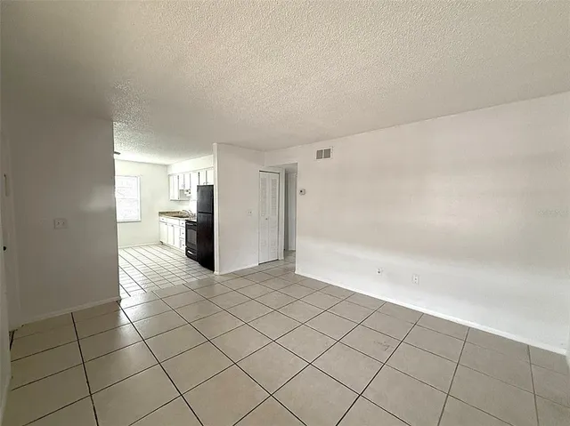 a view of a refrigerator in kitchen and white cabinets