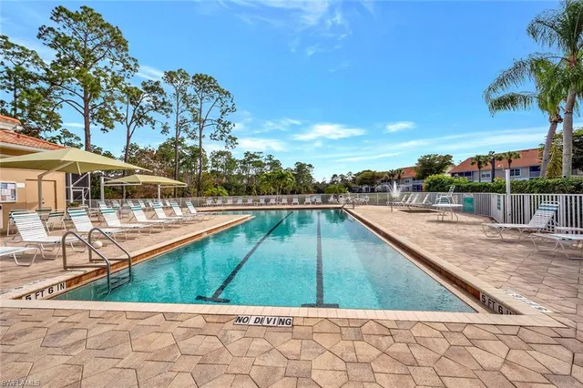 a view of swimming pool with a yard and large trees