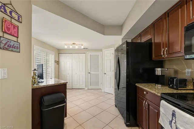 a kitchen with stainless steel appliances granite countertop a stove refrigerator and sink