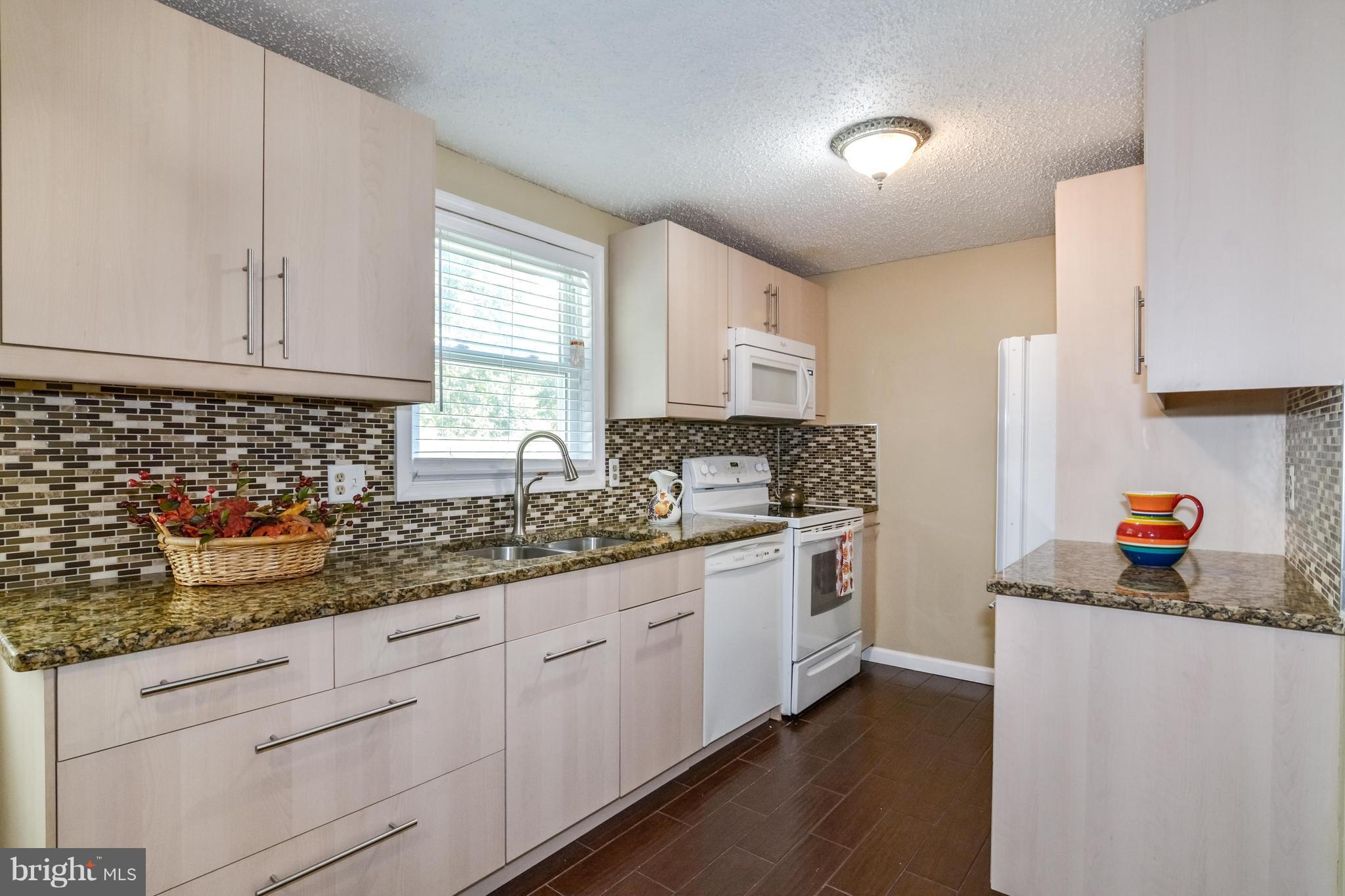 8609 Spring Creek Court Springfield, VA 22153 - Photo 1 of 30 a kitchen with granite countertop white cabinets and white appliances