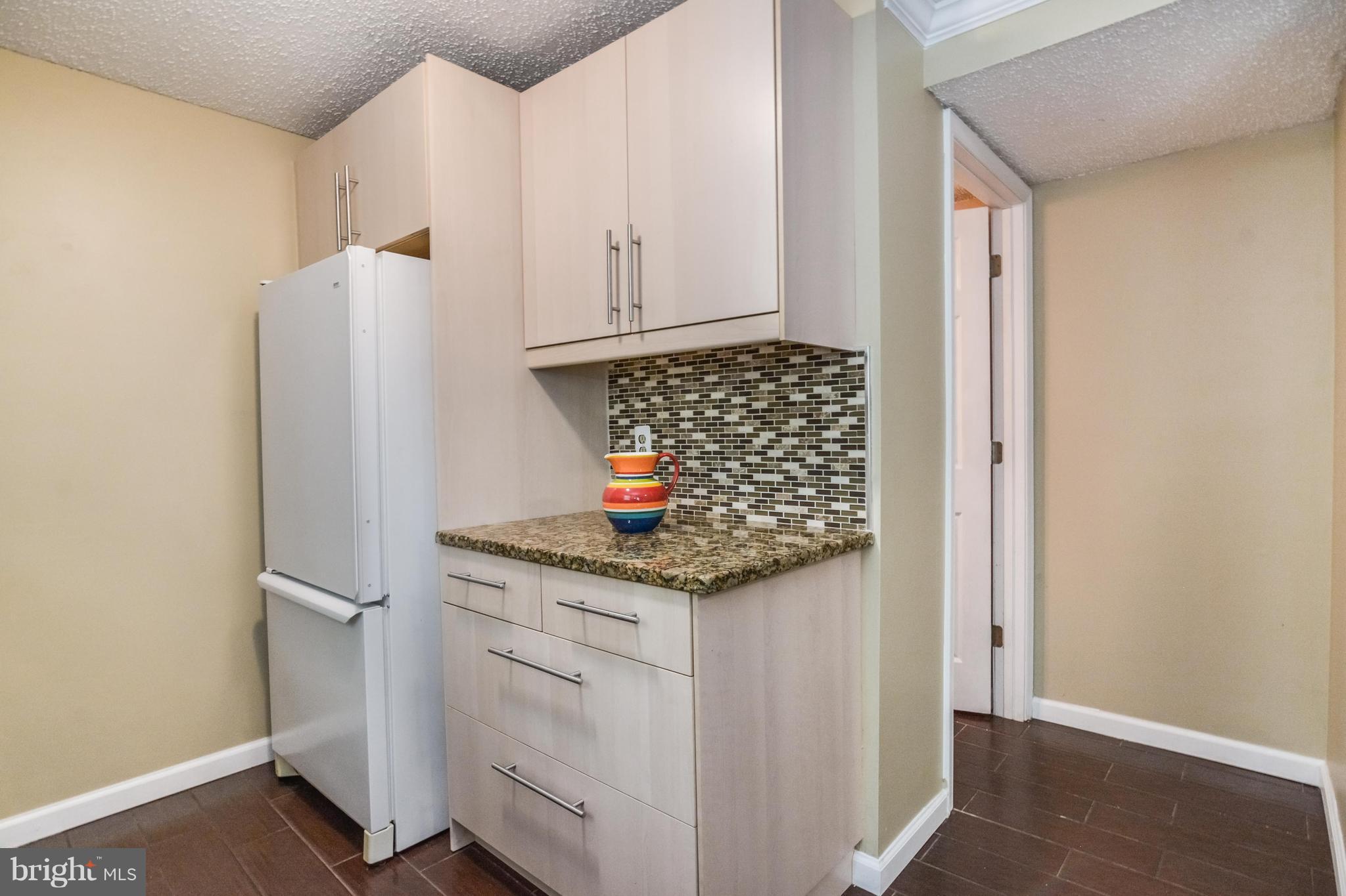 8609 Spring Creek Court Springfield, VA 22153 - Photo 4 of 30 a kitchen with white cabinets and white appliances