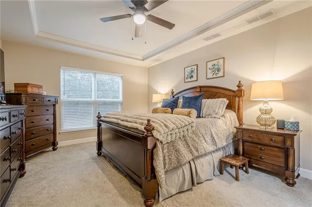 a bedroom with a bed a couch and a flat screen tv