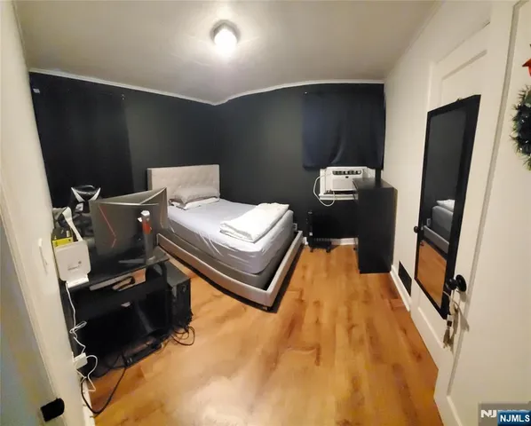a bedroom with a bed and wooden floor