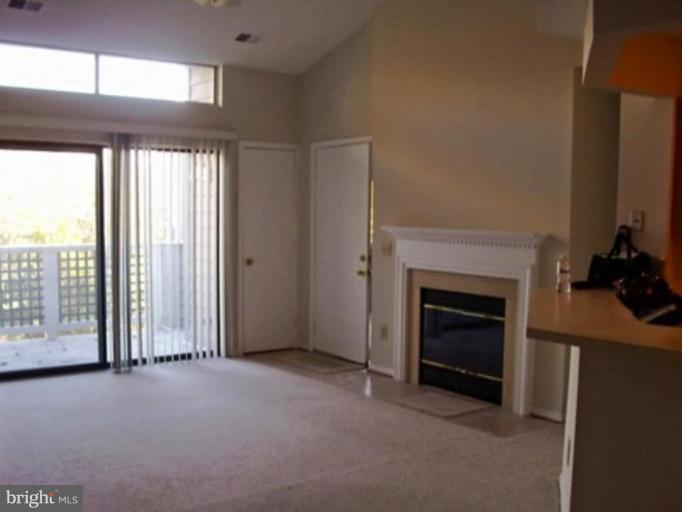 11703 Summerchase Circle, Unit E Reston, VA 20194 - Photo 4 of 6 a view of an empty room with a fireplace and a window