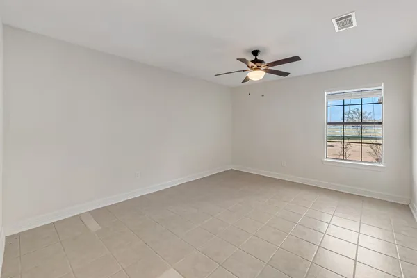 an empty room with a window and a fan