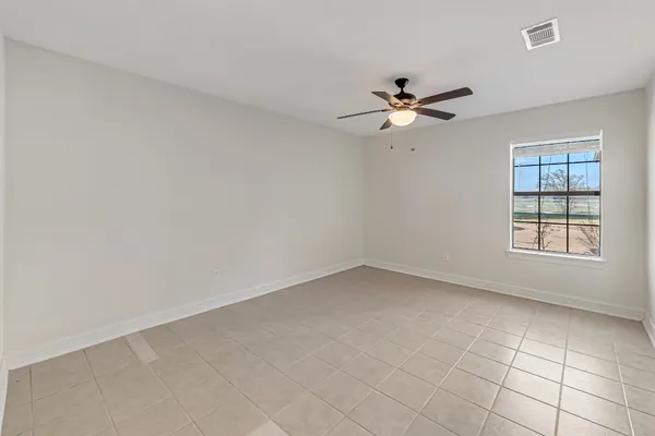 an empty room with a window and a fan