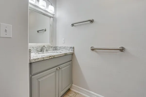 a bathroom with a granite countertop sink and a mirror