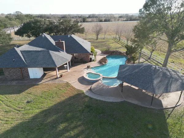an aerial view of a house with garden space and a lake view