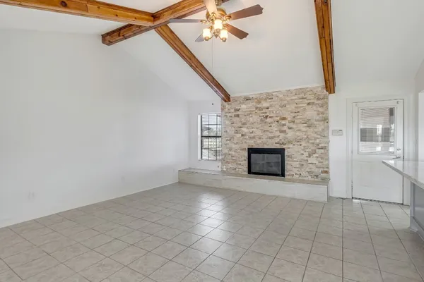 an empty room with windows and fireplace