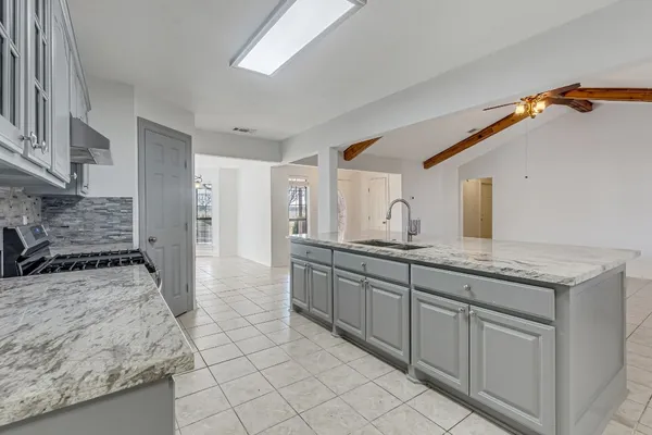 a large kitchen with granite countertop a sink and a stove