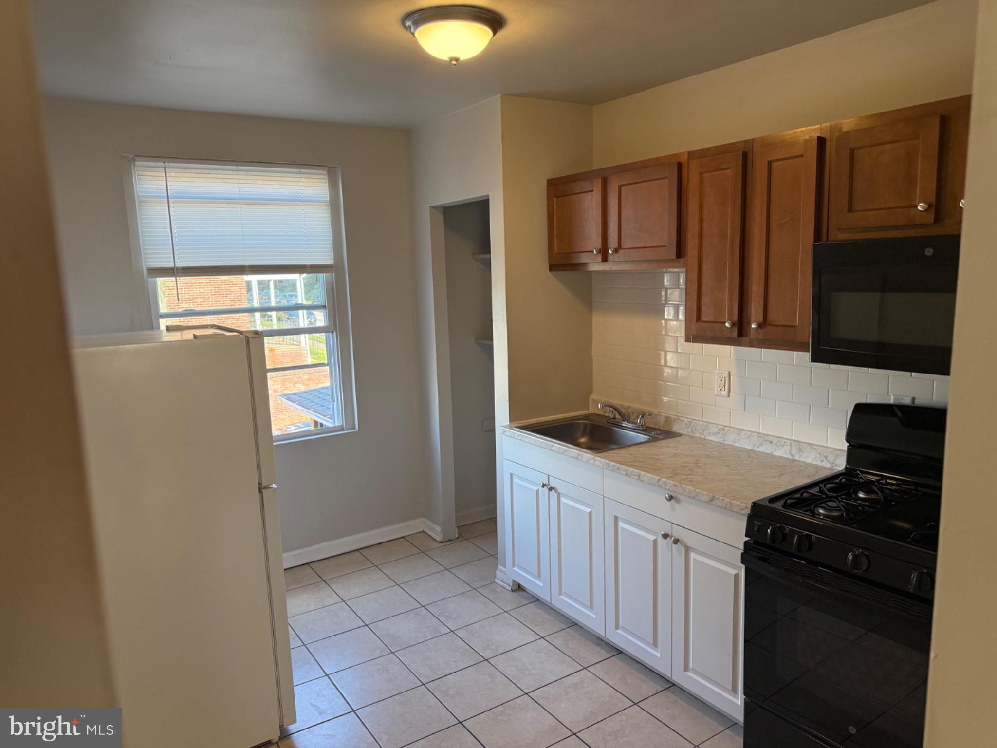 2803 Edison Highway, Unit 2 Baltimore, MD 21213 - Photo 2 of 11 a kitchen with stainless steel appliances granite countertop a stove a sink and a refrigerator