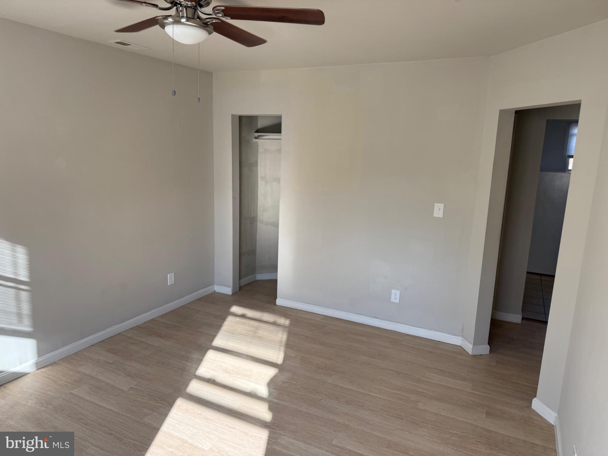 2803 Edison Highway, Unit 2 Baltimore, MD 21213 - Photo 5 of 11 wooden floor in an empty room with a window