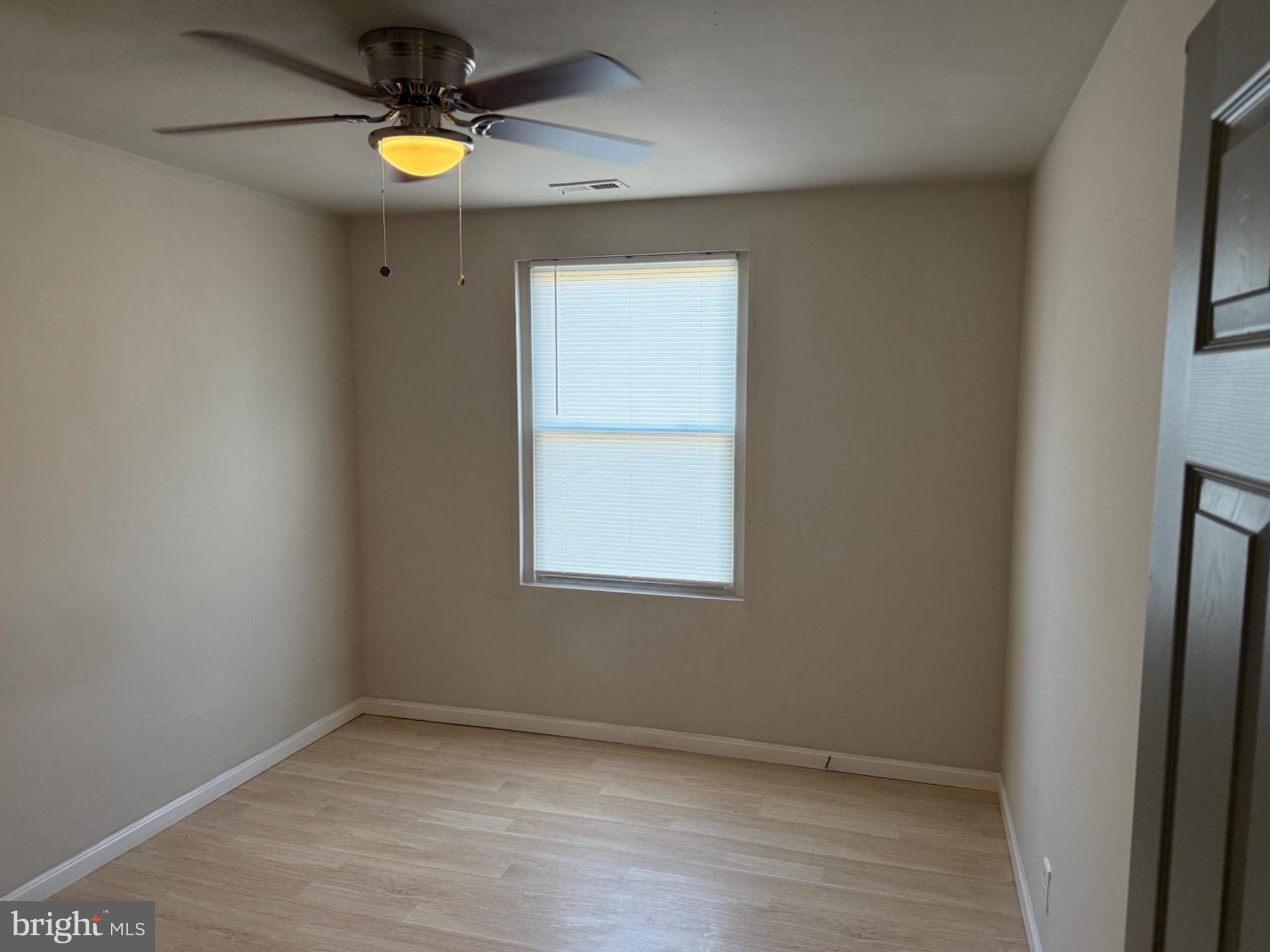 2803 Edison Highway, Unit 2 Baltimore, MD 21213 - Photo 6 of 11 an empty room with a window and a fan