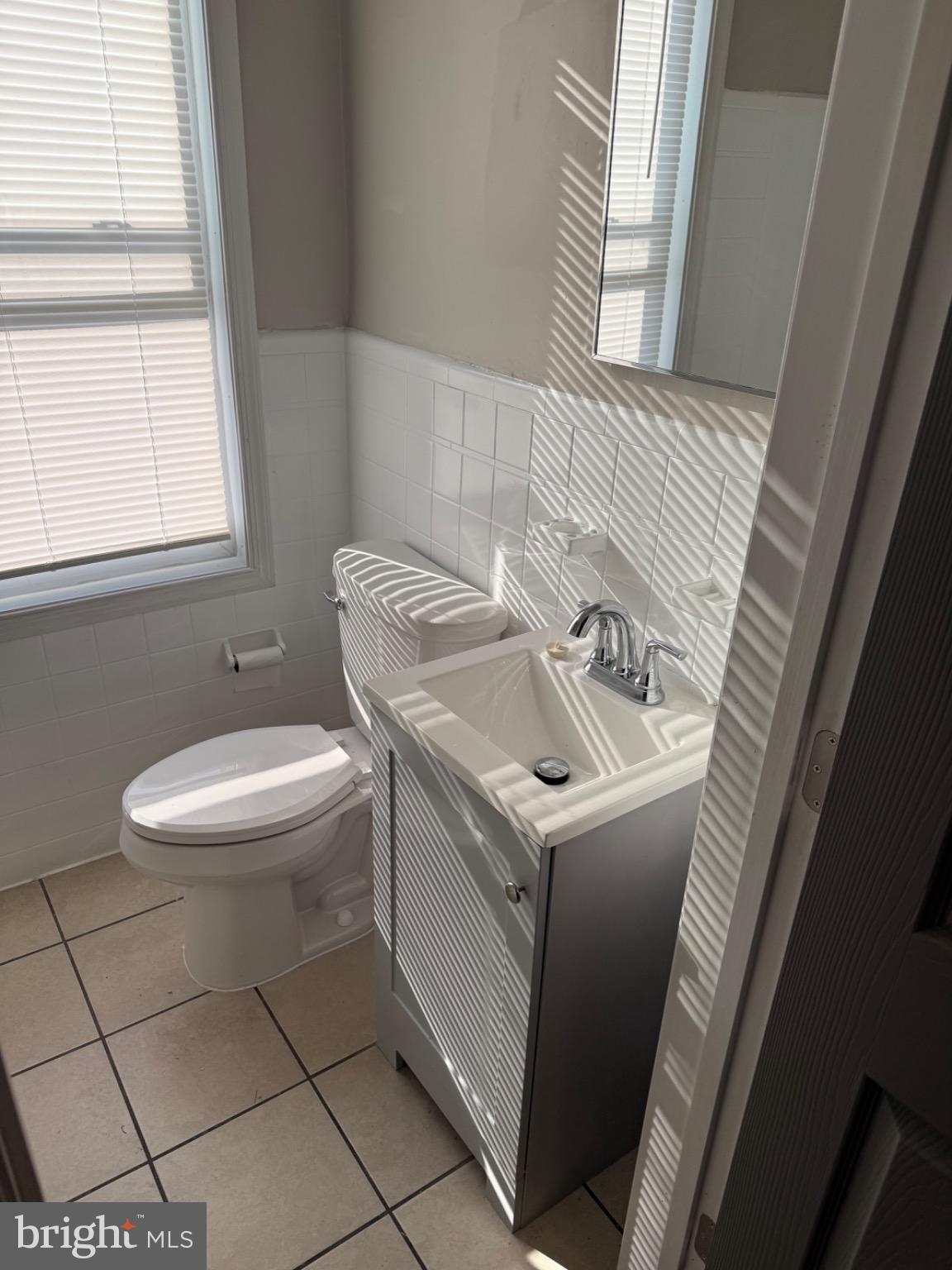2803 Edison Highway, Unit 2 Baltimore, MD 21213 - Photo 9 of 11 a bathroom with a sink a toilet and a window