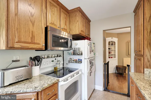 a kitchen with stainless steel appliances granite countertop a refrigerator and a stove top oven