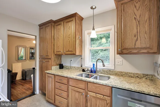 a kitchen with stainless steel appliances granite countertop a sink a stove and cabinets