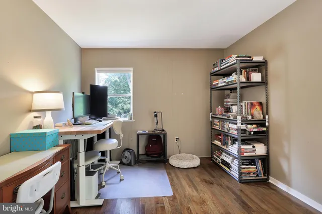 a view of a workspace with furniture and wooden floor
