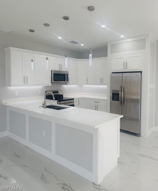165 Patio Street Lehigh Acres, FL 33974 - Photo 18 of 34 Kitchen featuring appliances with stainless steel finishes, white cabinetry, hanging light fixtures, a peninsula, and recessed lighting