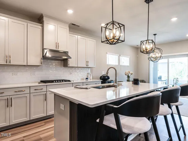 a kitchen with cabinets table and chairs