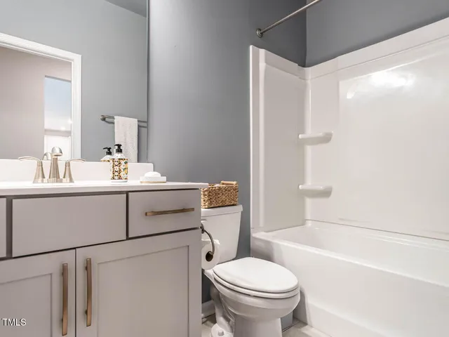 a bathroom with a sink toilet vanity and shower