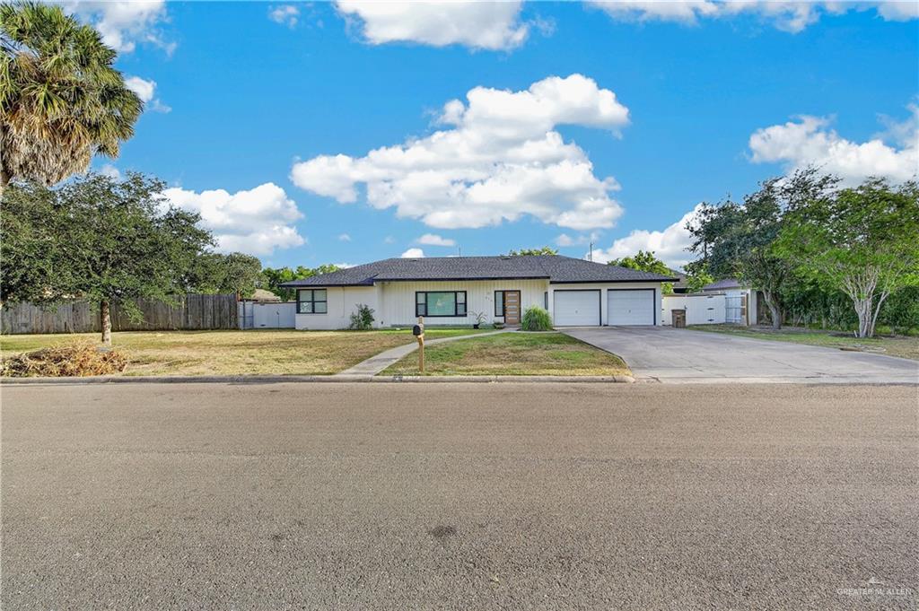 216 West Enfield Road Edinburg, TX 78539 - Photo 3 of 20 White exterior with dark trim windows, two-car garage, and a concrete driveway