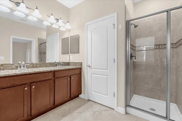 a bathroom with a granite countertop sink a mirror and a shower