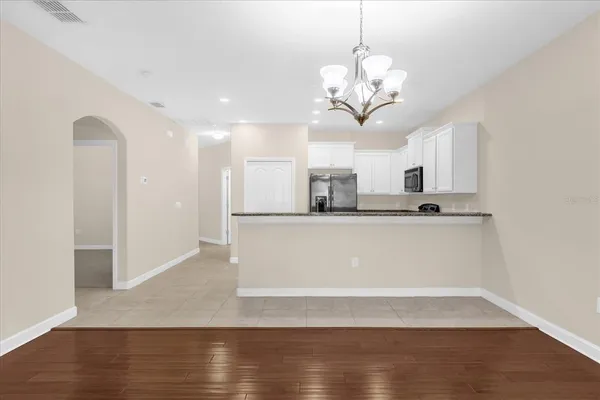 a view of kitchen with granite countertop cabinets and refrigerator