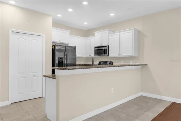 a kitchen with stainless steel appliances a refrigerator sink and microwave