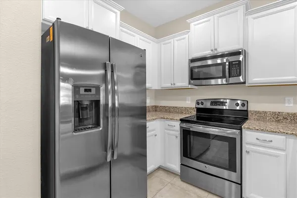 a kitchen with stainless steel appliances granite countertop a refrigerator stove and microwave