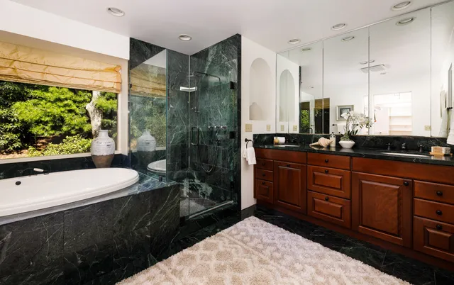 a bathroom with a sink a large mirror and a bathtub