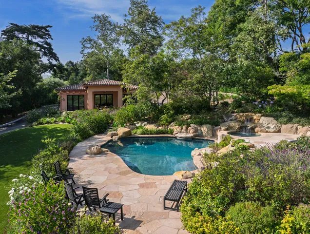 a view of a house with pool garden and patio