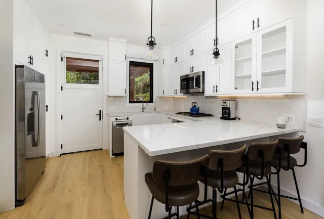 a kitchen with stainless steel appliances a table chairs and a refrigerator