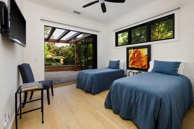 a bedroom with two beds and a flat screen tv