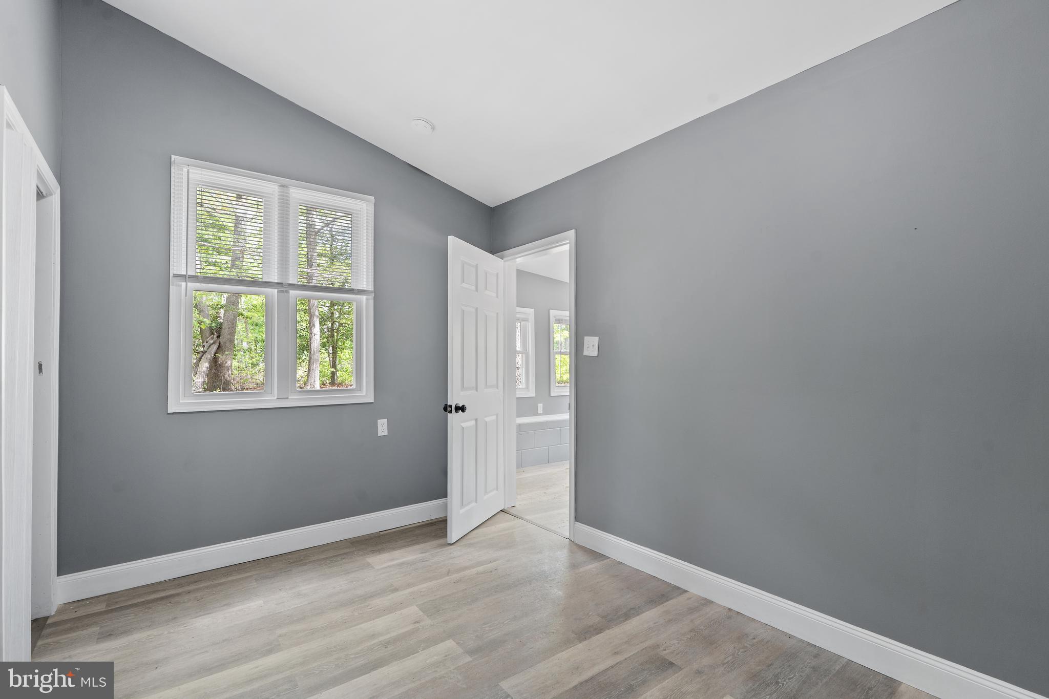 328 Jute Road Millville, NJ 08332 - Photo 18 of 28 an empty room with wooden floor and windows