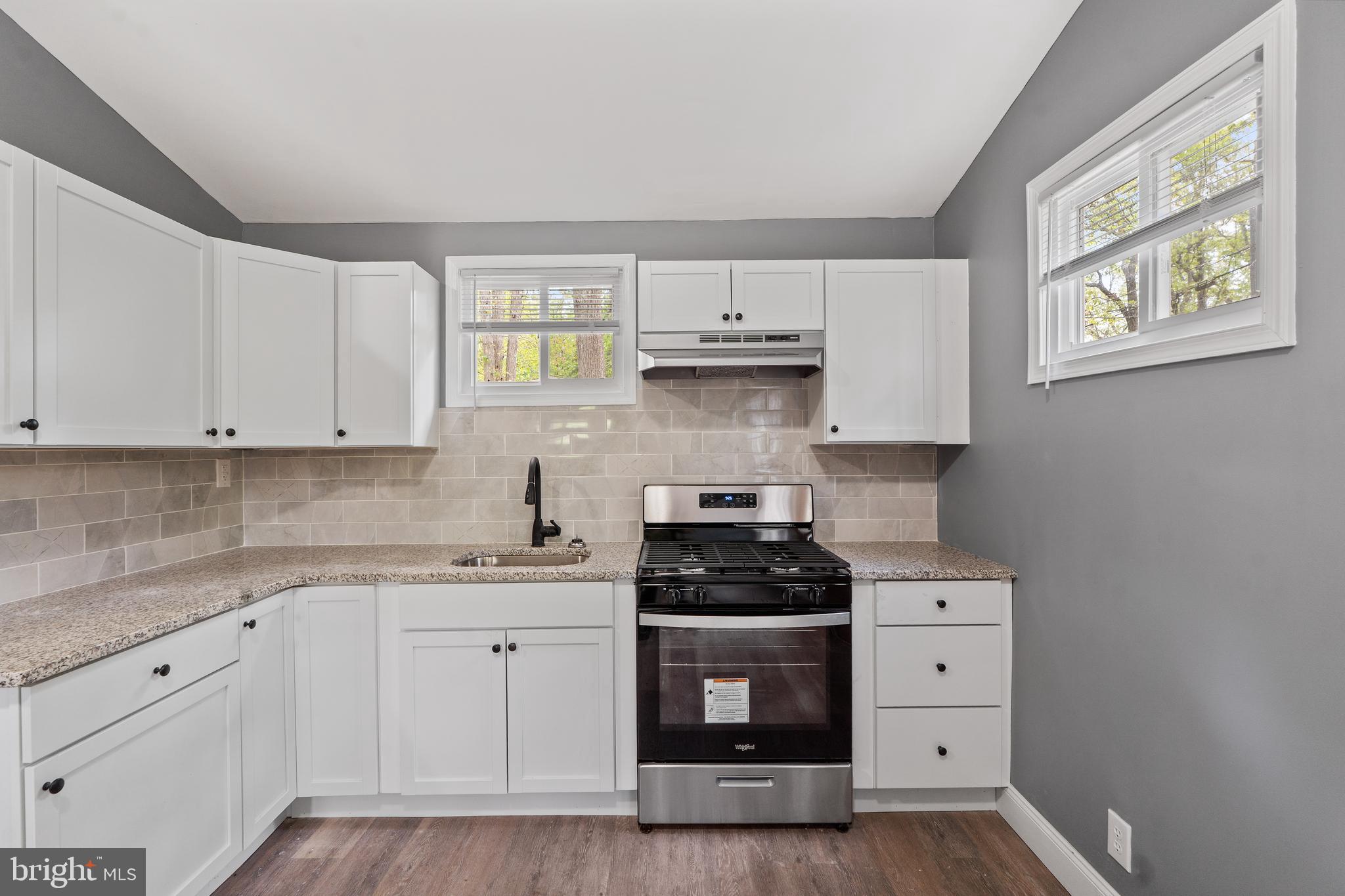328 Jute Road Millville, NJ 08332 - Photo 7 of 28 a kitchen with stainless steel appliances a stove a sink and white cabinets