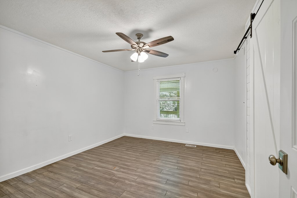 1146 Galloway Road Blue Ridge, GA 30513 - Photo 13 of 33 a view of an empty room with a window and a ceiling fan