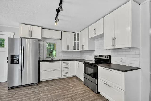 a kitchen with white cabinets and stainless steel appliances