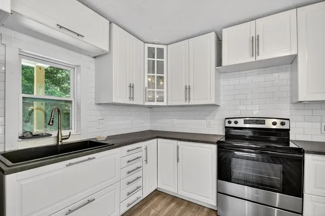 a kitchen with granite countertop white cabinets and appliances