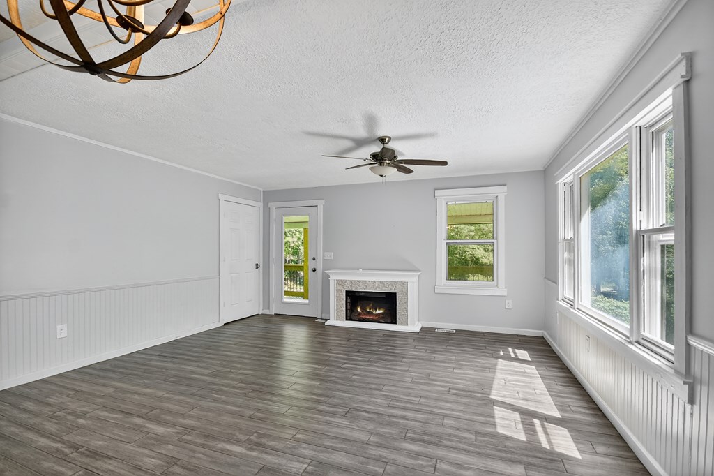 1146 Galloway Road Blue Ridge, GA 30513 - Photo 9 of 33 an empty room with windows fireplace and wooden floor